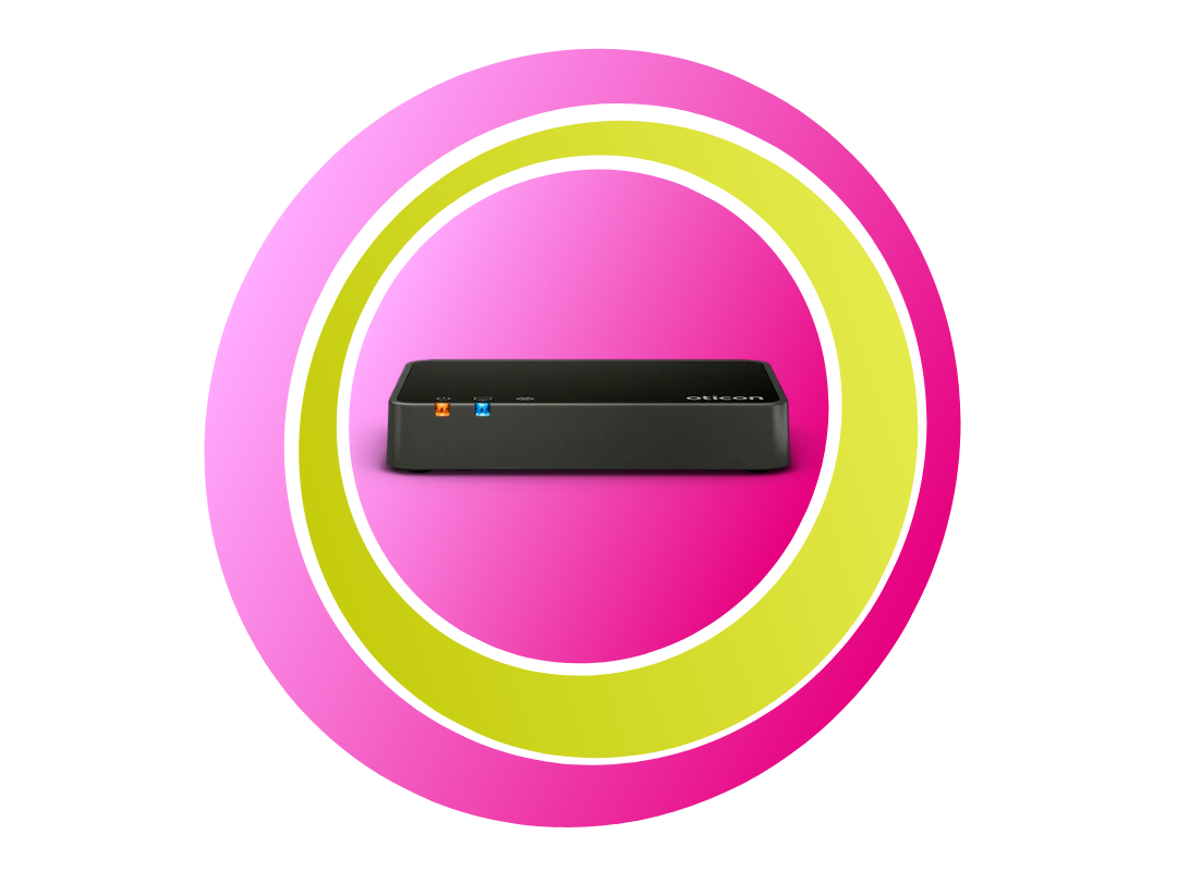 Pinke und grüne Ringe mit dem Oticon TV Adapter in der Mitte.