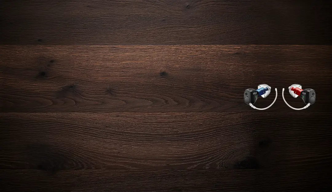 Oticon Zeal Hoergeraete praesentiert auf einem Holztisch mit einer Tasse Kaffee, einer Smartwatsch, am oberen Bildrand ist eine Ladestation zu erkennen